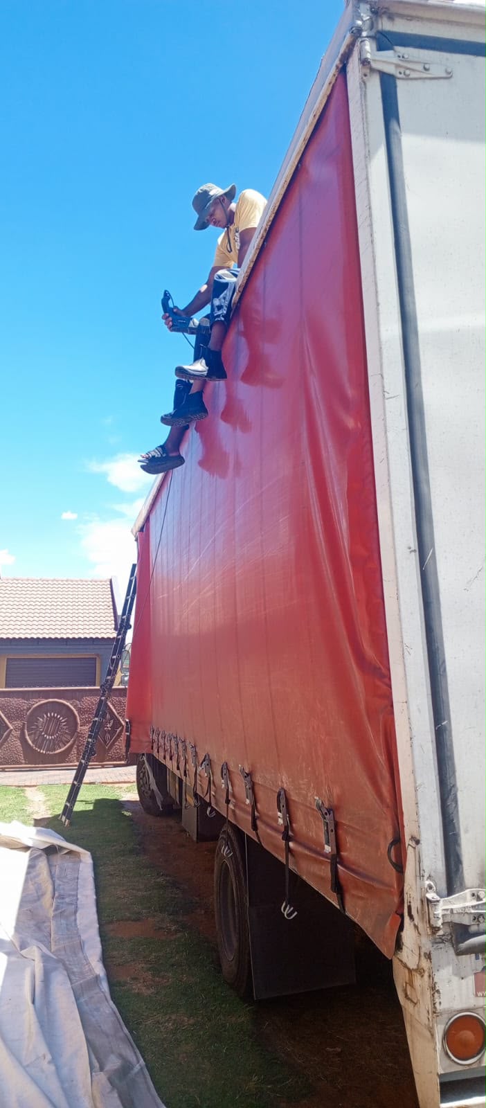 Technician repairing a damaged truck curtain on site
