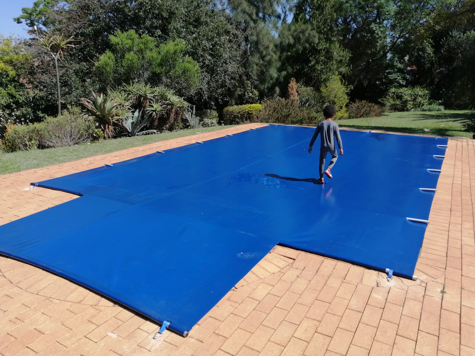 Custom blue PVC pool cover fitted over a swimming pool in Johannesburg